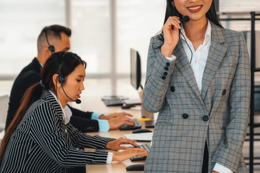 Business people wearing headset working in office to support remote customer or colleague. Call center, telemarketing, customer support agent provide service on telephone video conference call. Jivy