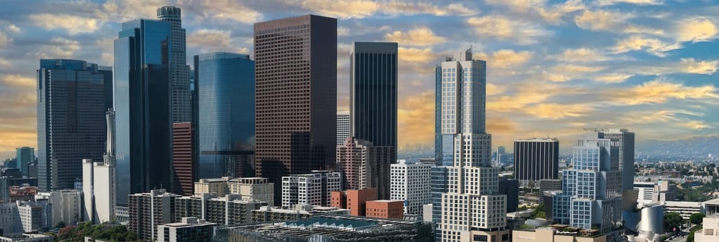 Panorama of Los Angeles, CA downtown cityscape in colorful morning light. Skyscrapers of the western financial center of North America . Hero style blue sky and yellow and white clouds. High quality photo