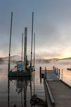 A small barge by a dock at sunrise in Hauser Lake, Idaho.