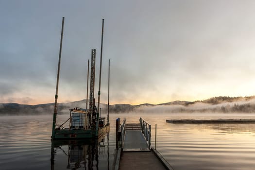 A small barge by a dock at sunrise in Hauser Lake, Idaho.