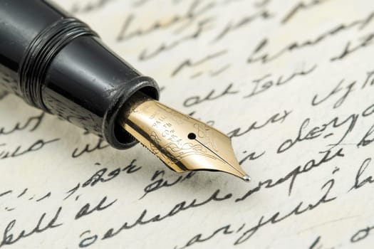 Close-up of an elegant fountain pen resting on vintage handwritten letters...