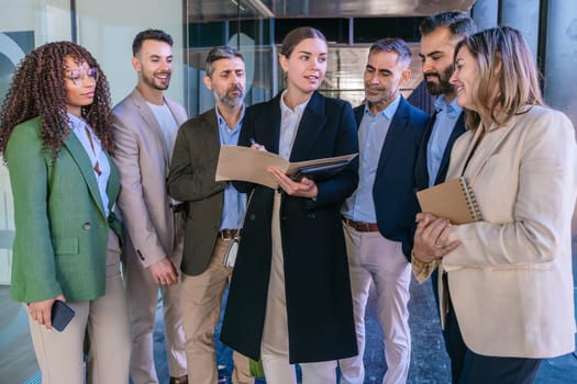 A diverse business team having a meeting and discussing ideas in a modern office. Professionals in formal attire collaborating with a notebook and tablet. Perfect for teamwork, business, and planning themes.