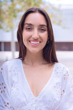 Portrait of woman with a smiling, Focus on her facial features and natural beauty, captured outdoors with soft lighting and an urban background.