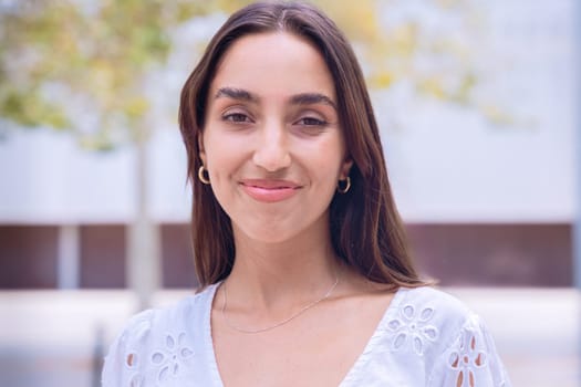 Portrait of a woman with a smiling, Focus on her facial features and natural beauty, captured outdoors with soft lighting and an urban background.