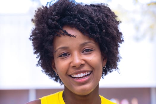 Portrait of black woman with a smiling, Focus on her facial features and natural beauty, captured outdoors with soft lighting and an urban background.