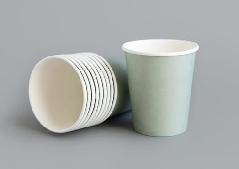 Light green paper disposable cup closeup isolated on grey. Template for graphics and advertising, mockup. Eco friendly, sustainable tableware. Zero plastic concept