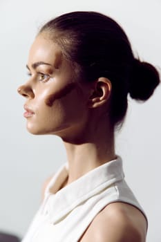 Profile portrait of a thoughtful young woman, highlighting her poise and sophistication. This image emphasizes natural beauty with striking lighting.