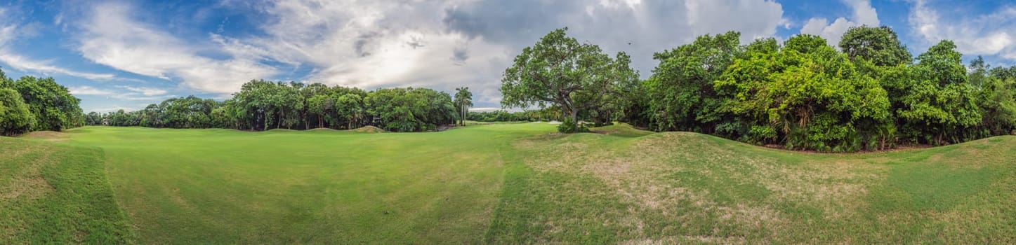 Scenic panorama of a tropical golf course surrounded by lush jungle. Serene landscape ideal for relaxation, sports, and luxury travel. Nature, recreation, and tropical getaway concept.