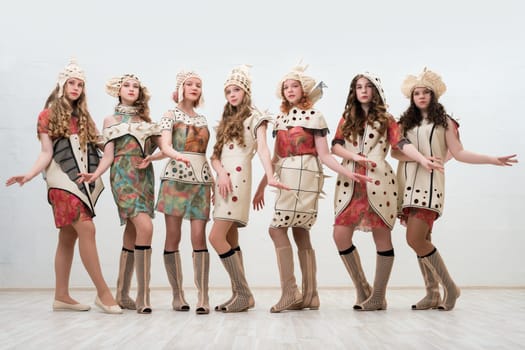 Pretty girls wearing fashion colorful dresses view against white wall