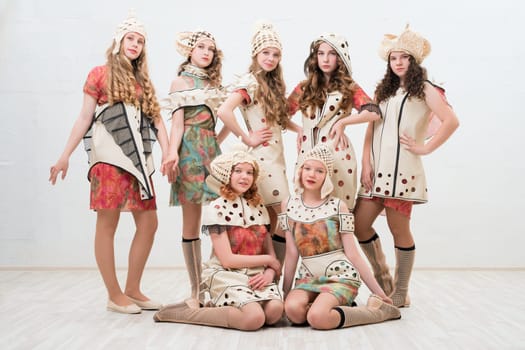Girls wearing fashion colorful dresses view against white wall