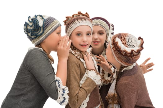 Adorable girls in knitted cute hat admiringly looking and gossiping merrily