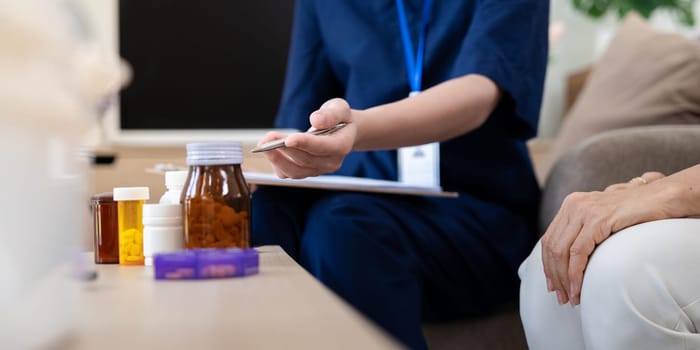 A caregiver provides clear instructions on medication dosage to an elderly client, showcasing dedication to personalized healthcare in a friendly home setting.