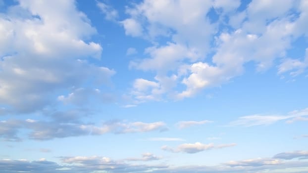 This stunning photograph captures a breathtaking view of a clear blue sky adorned with fluffy cumulus clouds. The image showcases a vast expanse of sky, with the clouds softly scattered across the frame, creating a sense of tranquility and serenity. The soft, natural light suggests a sunny day, making it ideal for projects needing a calming and peaceful atmosphere. Perfect for backgrounds in websites, presentations, or any design project requiring a tranquil sky backdrop. The image's high resolution ensures excellent quality even when enlarged. This image evokes feelings of peace, freedom, and the beauty of nature, adding a touch of elegance and sophistication to any design.