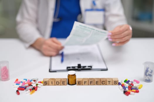 A healthcare professional reviews medication side effects while examining and documenting pills carefully