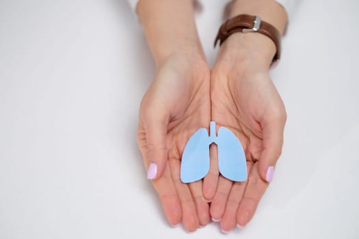 Closeup of hands holding a vibrant blue model of lungs, symbolizing health and respiratory awareness