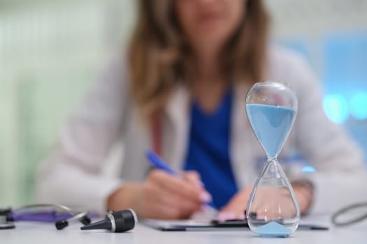 A medical professional emphasizes time managements critical importance in healthcare while working with an hourglass