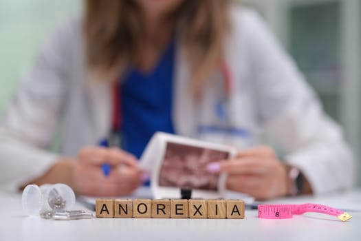 A healthcare professional carefully examines various materials and resources related to the issue of anorexia