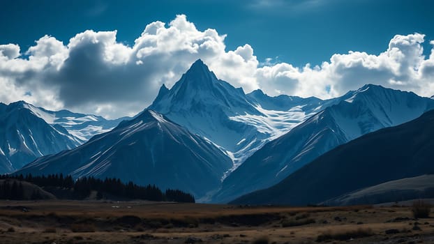 This stunning photograph captures the awe-inspiring beauty of a snow-capped mountain range against a backdrop of a vivid blue sky adorned with fluffy white clouds. The image showcases a sharp, majestic peak as its focal point, surrounded by a series of rugged, snow-dusted mountains that extend to the horizon. A tranquil valley with sparse vegetation lies in the foreground, offering a striking contrast to the towering peaks. The scene evokes a sense of adventure, tranquility, and the raw power of nature. This high-resolution image is ideal for use in travel brochures, websites, calendars, posters, and any project requiring stunning nature photography that conveys a sense of scale and wonder. The rich color palette and dramatic lighting make this image particularly striking and versatile.