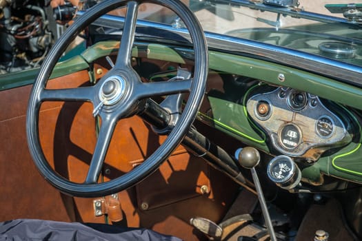Lisbon, Portugal - Sep 29, 2024: Green interior with steering wheel, gear stick and car dashboard of vintage Ford A Tudor Sedan in selective focus. Keys in ignition switch. Ford Motor Company, USA.