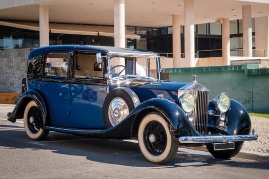 Lisbon, Portugal - Sep 29, 2024: Legendary and luxury 1937 Rolls-Royce Phantom III on sunny day in urban setting. Front grille, radiator, headlights and iconic bonnet mascot of Spirit of Ecstasy. Last car designed by Henry Royce.