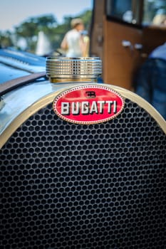 Lisbon, Portugal - Sep 29, 2024: Close view of hood and grille of original dark blue lacquered Bugatti Type 40 Grand Sport car parked in driveway near other historic car model. Grand tourer car or roadster, 1930s, by Bugatti, France.