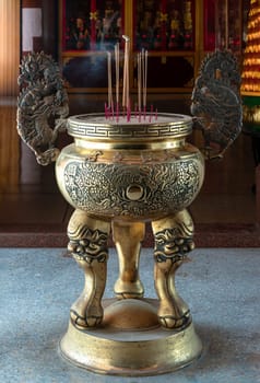 Samut Prakan, Thailand - Jan 11, 2025 - Metal dragons sculpture decorate on Golden incense burner (Incense smoke burning straight up) inside the Buddhist temple of Wat Dhammakatanyu (Xian Lo Dai Tien Gong). Taiwanese art style, use it as your Wallpaper, Poster and Space for text, Selective focus.
