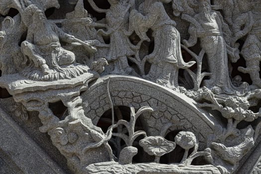 Samut Prakan, Thailand - Jan 11, 2025 - The relief on Elaborate sculptured of Stone carvings is a beautiful Taiwanese art style. Surface texture of Stucco art in Taiwan temple, use it as your Wallpaper, Poster and Copy space, Selective focus.
