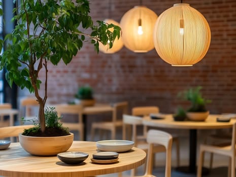 A cozy restaurant interior featuring wooden tables, elegant pendant lights, and green plants. The warm lighting and minimalist design create a welcoming ambiance, perfect for a relaxing dining experience.