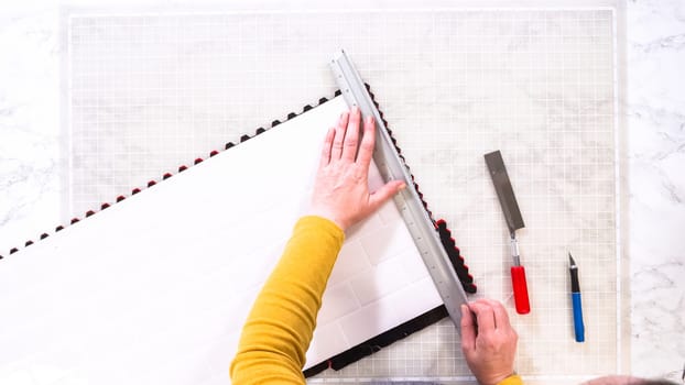 Flat lay. In the process of mounting peel and stick mosaic tiles onto a foam board, perfect for enhancing a food photography studio's aesthetic.