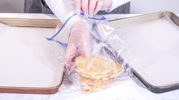 The sugar cookies, filled with sprinkles mixed into the dough, are carefully arranged with meticulous precision into a rustic brown paper box.