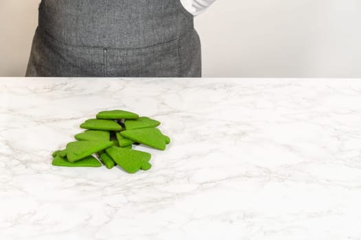 An eye-level view of a piece of green gingerbread dough resting on a marble surface, prepared for the next steps in the Green Gingerbread Cookies recipe. The dough smooth surface hints at a well-kneaded, vibrant preparation.