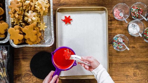 Flat lay. Creating snowflake-shaped cutout sugar cookies, dipped in chocolate, and adorned with different toppings.