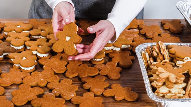Crafting gingerbread cookie sandwiches with eggnog buttercream, presented on a rustic wooden table for Christmas gifting.
