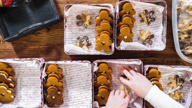 Flat lay. Lovingly homemade gingerbread and sugar cookies, half-dipped in rich chocolate, nestled in decorative Christmas tin boxes perfect for seasonal gifting.