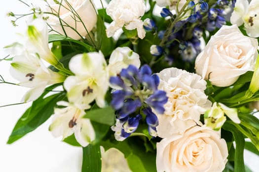 A stunning bouquet featuring fresh white roses and assorted flowers gracefully arranged in a vase, exuding timeless beauty.