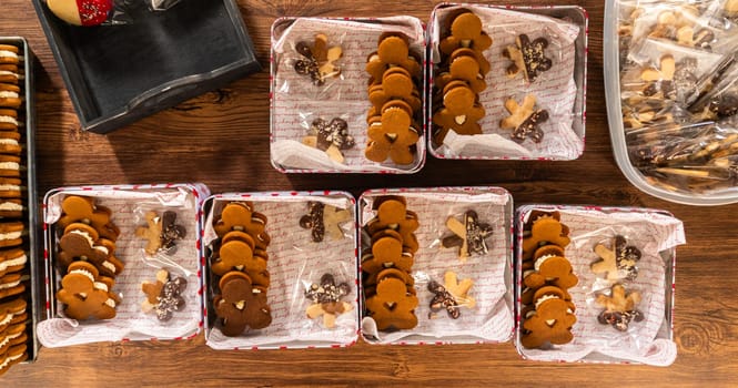 Lovingly homemade gingerbread and sugar cookies, half-dipped in rich chocolate, nestled in decorative Christmas tin boxes perfect for seasonal gifting.