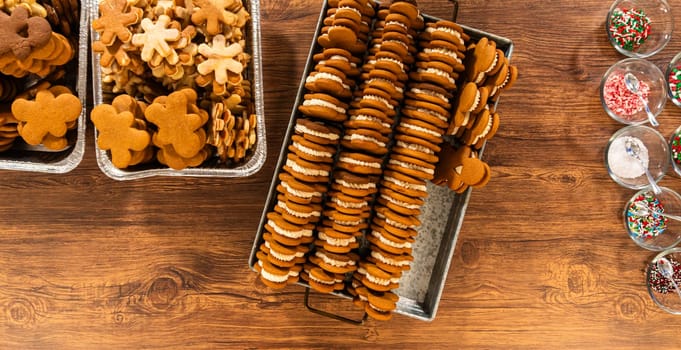 Crafting gingerbread cookie sandwiches with eggnog buttercream, presented on a rustic wooden table for Christmas gifting.