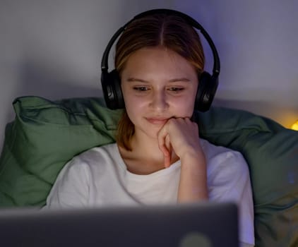 Cute Little Girl Finds It Interesting To Listen To A Podcast With Headphones In Bed Before Sleep