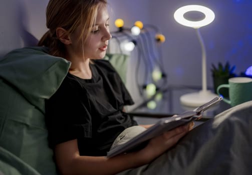 Cute Little Girl In Bed Reading A Book Aloud Before Sleep