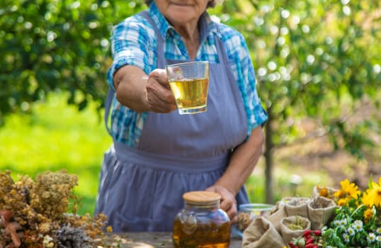 Medicinal herbs and tea old woman. Selective focus. Nature.