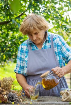 Medicinal herbs and tea old woman. Selective focus. Nature.
