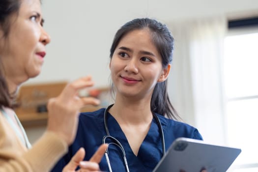 A caregiver smiles and listens attentively to an elderly woman, highlighting the importance of communication and empathy in patient care.