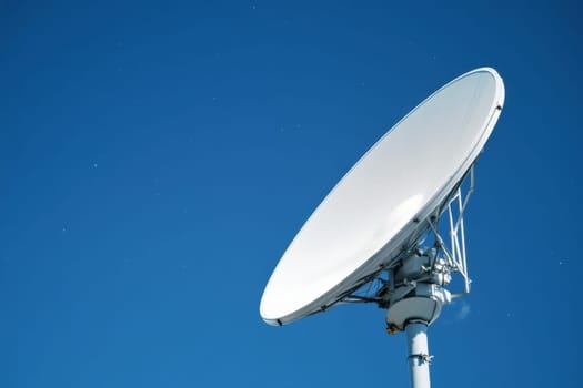 A detailed close-up of a satellite dish against a clear blue sky, designed for scanning stars and receiving signals, showcasing modern technology and communication capabilities.