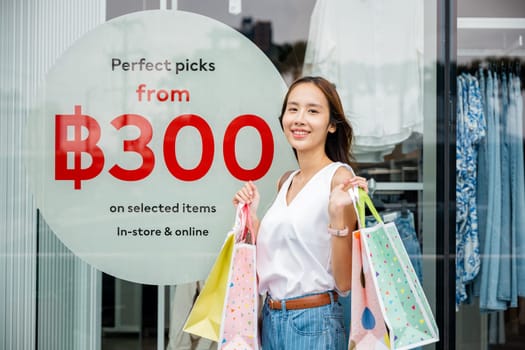 A woman carrying her shopping bags, excited about her purchases in the city's fashion district. Retail, consumerism, and urban lifestyle.