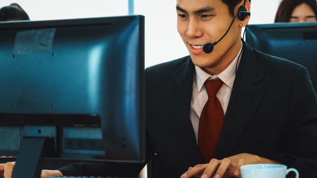 Business people wearing headset working in office to support remote customer or colleague. Call center, telemarketing, customer support agent provide service on telephone video conference call. Jivy