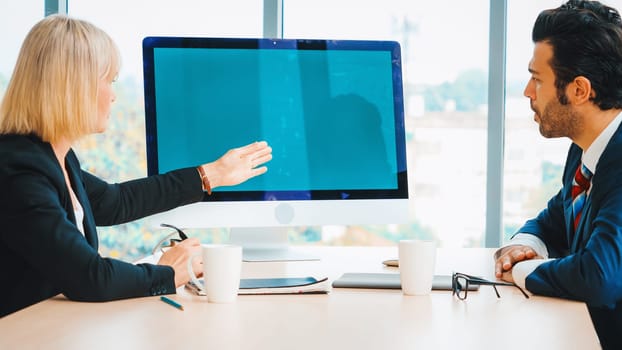 Business people in the conference room with green screen chroma key TV or computer on the office table. Diverse group of businessman and businesswoman in meeting on video conference call . Jivy