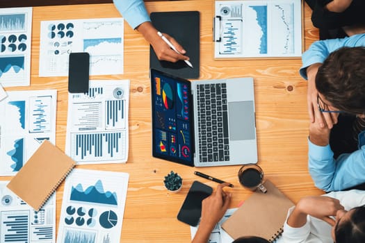 Top view diverse group of business analyst team analyzing financial data report paper on meeting table. Chart and graph dashboard by business intelligence analysis. Habiliment