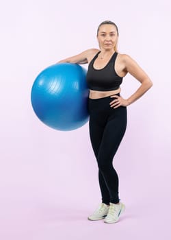 Full body length shot athletic and sporty senior woman with fitness exercising ball on isolated background. Healthy active and body care lifestyle after retirement. Clout