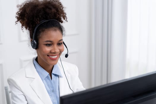 African American young businesswoman wearing headset working in office to support remote crucial customer or colleague. Call center, telemarketing, customer support agent provide service on video call