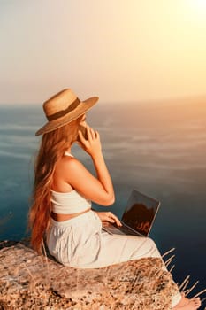 Freelance happy woman typing on her laptop, enjoying the picturesque sea view, highlighting the idea of working remotely with a relaxed and pleasant atmosphere